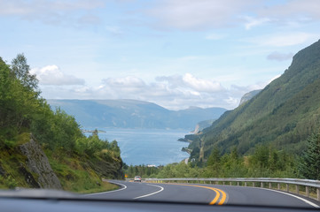 Norwegian road trip, a view on the road and fjord by the car