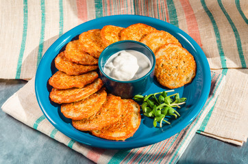 Homemade potato pancakes, latkes, draniki, hash browns or fritters served with sour cream and sunflower sprouts. Traditional Hanukkah treats. Closeup