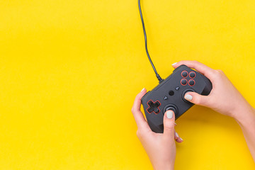 Hands Holding Gamepad. Black joysticks on yellow background. Computer game competition. Gaming...