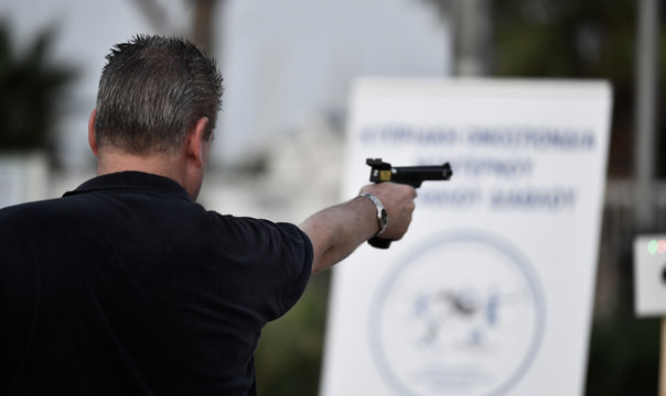 Adult aiming with a hand gun a sports event