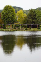 Der Kurpark von Weiskirchen im Saarland Deutschland mit einem See und überdachter Holzbrücke