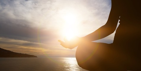 Human silhouette meditating at sunset, yoga relax