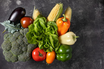 Fresh vegetables in a wooden box on a dark wooden background.