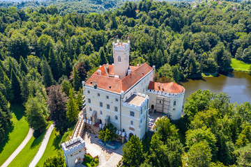 Obraz premium Aerial view of old castle of Trakoscan on lake in green wood in Zagorje, Croatia on sunny summer day
