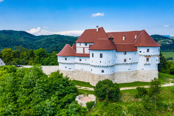 Fototapeta na wymiar Aerial view of red roof of old medieval castle Veliki Tabor and green hills in Zagorje, northern Croatia on sunny summer day