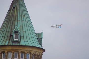 Obraz premium Der Turm von der state savings bank in Luxemburg Stadt mit einem Flugzeug im Hintergrund, der gerade im Anflug auf den Luxemburg Flughafen ist