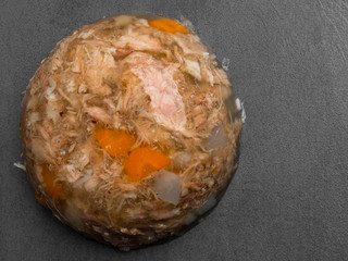 jellied meat with carrots, garlic on grey background