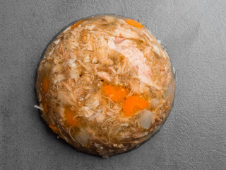 jellied meat with carrots, garlic on grey background