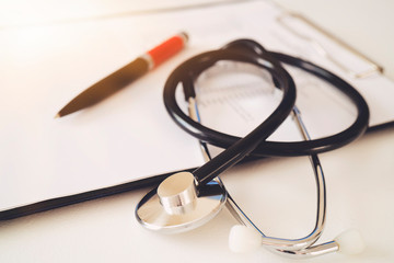Stethoscope with prescription clipboard, Healthcare and medical concept, test results in background, vintage color, selective focus