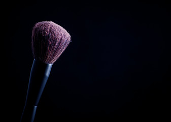 Makeup brush with pink on the black background