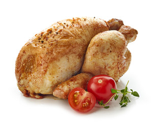 Roasted whole chicken with fresh tomatoes and greens isolated on white background