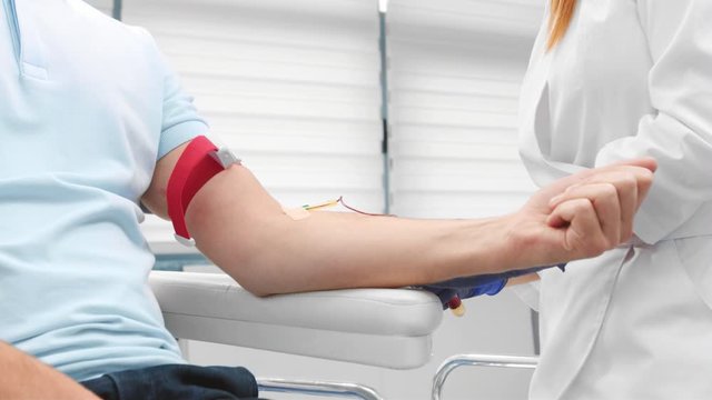 Nurse drawing blood for platelet-rich plasma treatment.