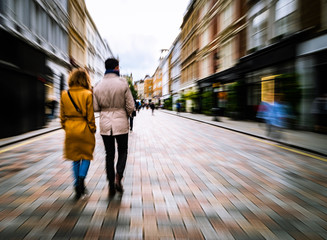 Couple walking on shopping street. Abstract motion blurred