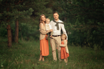 Naklejka na ściany i meble father, mother, daughter and son standing in the forest, Full Length shot