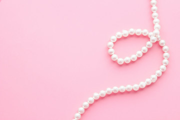 Pearls on pastel pink background