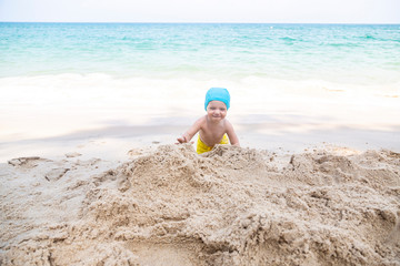 little girl playing in the sand on the beach