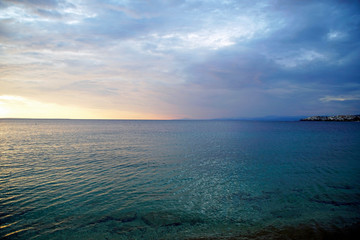Horizontal shot. Empty beach in the evening at sunset. . Silhouettes and coastline. Sea bright sky. Greece Sithonia. Horizon. Clouds and rays of the sun. Bird island