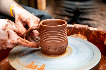 making clay mug in the pottery