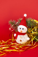 Snowman and fir branch on a red background. Christmas background