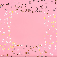 Golden and silver stars on pink pastel background.
