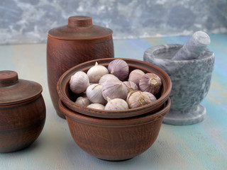 Garlic is in a clay bowl.On light background