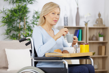 happy handicapped senior woman having a cup of coffee
