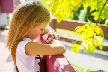 Obraz premium Modern technology for children. School girl using her GPS smart watch. GPS kids tracker, kids tracking and parental control concept