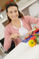 Obraz na płótnie Canvas happy woman cutting vegetables in the kitchen