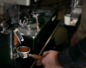 Macro shot grinding coffee on professional grinder machine