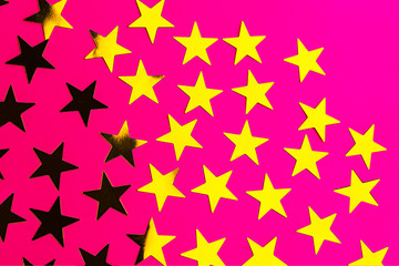 Bunch of gold stars on pink red background.