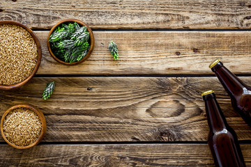 Barley and hop for making beer on rustic wooden background top view copy space