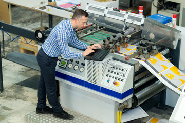 manworking on printing machine in print factory