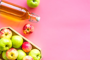 Vinegar made from fresh apple on pink background top view copy space