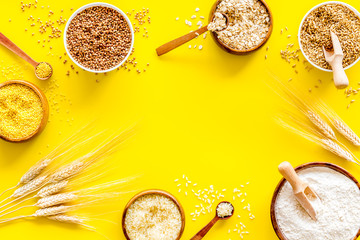 Healthy food concept. Cereals in bowls on yellow background top view frame copy space