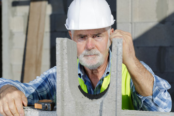 male engineer in a white helmet holding concrete blocks