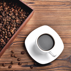 white coffee cup, morning side light coffee beans wooden box with coffee, top view natural wooden background