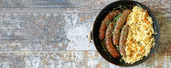 Banner. Oktoberfest food. Bavarian sausages and sauerkraut in a pan. Fresh Bavarian beer food....