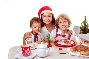 Three happy kids eating a christmas apple pie at home with new year decorations isolated on white background
