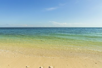 Beautiful view of Atlantic ocean sand beach. Yellow sand turning into dark blue water that merges ...