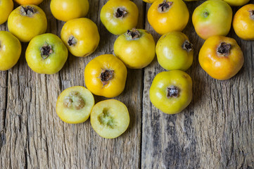 Fresh ripe yellow hawthorn fruits on wooden rustic background. Crataegus monogyna berries, healthy food for heart