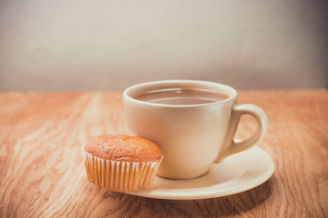 Muffin with coffee cup on wooden table. Selective focus. Coffee break
