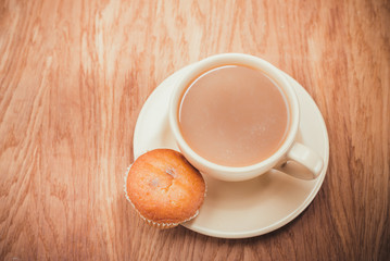 Muffin with coffee on wooden textured background. Top view. Coffee break