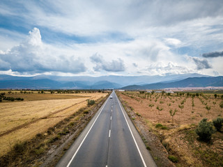 Aerial View Of Straight Tarred Road Through Guadix, Granada. In the background Sierra Nevada
