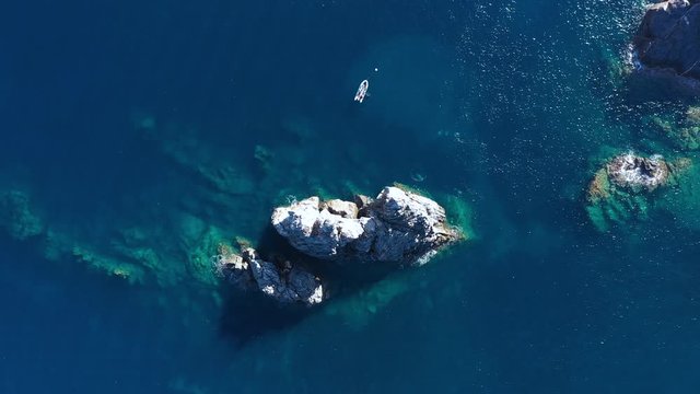 Scuba divers around the rocher de m&egrave;des Porquerolles mediterranean sea France aerial top shot