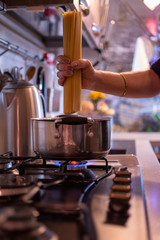 girl cooks spaghetti in a stainless steel pan