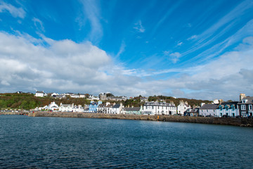 Looking at view of Portpatrick waterfront in Dumfries and Galloway in Scotland. Sunny day in autumn in the south west of Scotland. Scottish houses in seaside village.