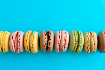 Top view of a colorful french macaron dessert on a blue background
