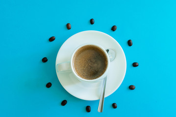 coffee beans around a cup of coffee representing the hours of a clock
