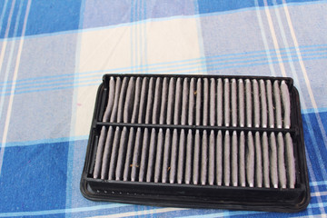 Filtro de aire de automóvil sucio. Sobre una mesa con mantel.