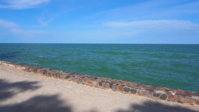 A stone sea wall defines the border between the ocean and land 
